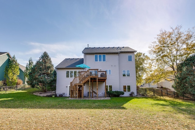 back of property with a deck and a lawn