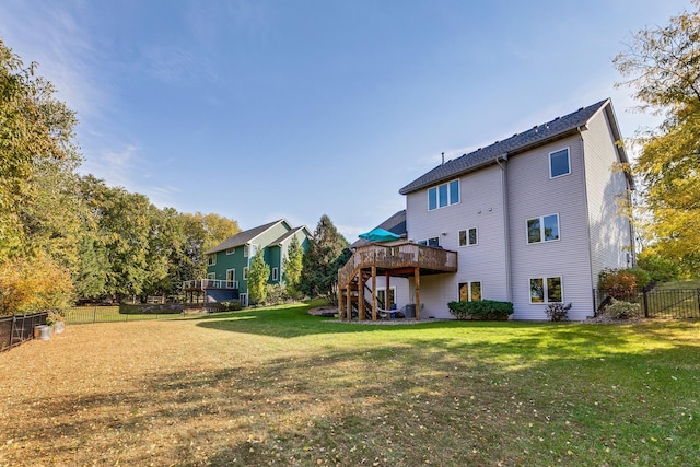 back of property with a lawn and a wooden deck