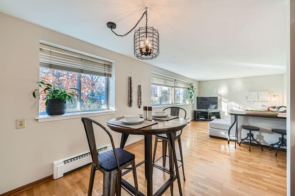 dining space with baseboard heating, a chandelier, and light wood-type flooring