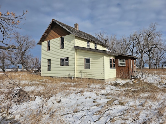 view of snow covered rear of property