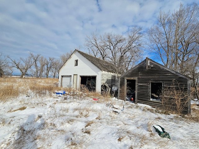 snow covered structure with a garage