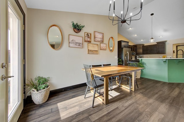 dining area featuring a wealth of natural light, dark wood-type flooring, lofted ceiling, and an inviting chandelier