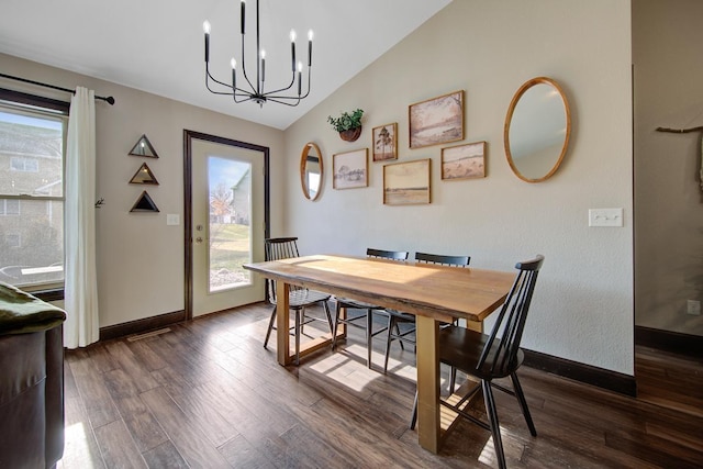 dining space featuring dark hardwood / wood-style flooring, an inviting chandelier, and vaulted ceiling