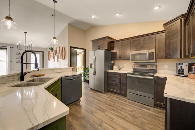 kitchen featuring decorative light fixtures, dark brown cabinetry, stainless steel appliances, and lofted ceiling