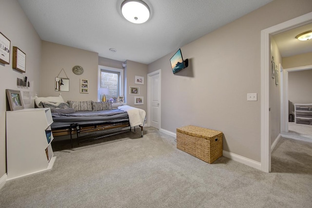 bedroom featuring a textured ceiling and light carpet