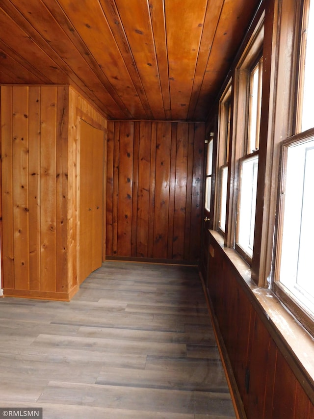 interior space with wooden walls, wood-type flooring, and wooden ceiling