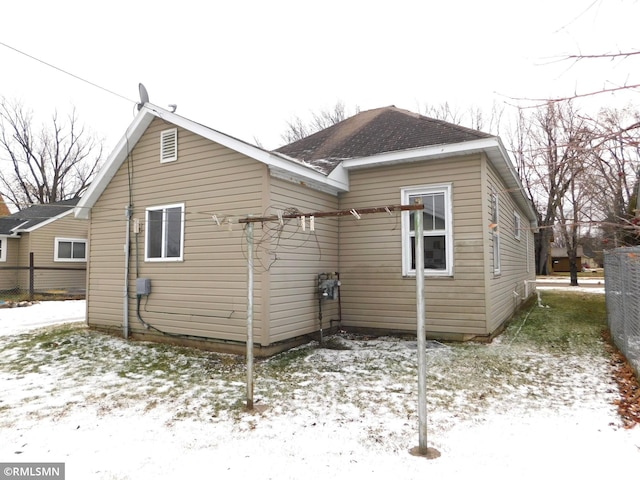 view of snow covered back of property