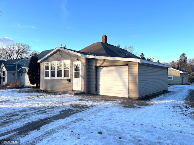 snow covered property with a garage