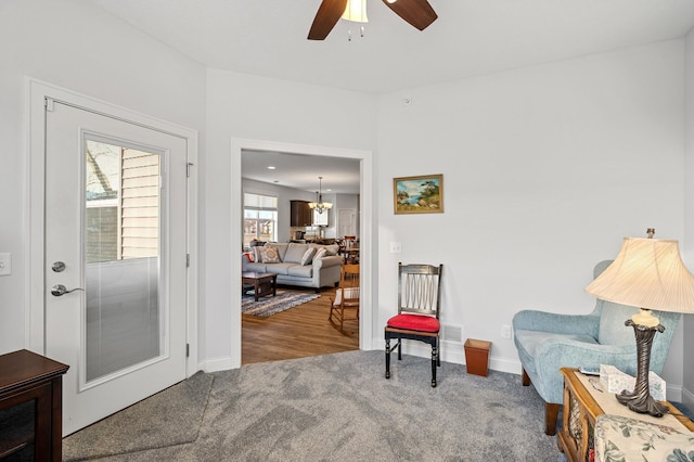 sitting room with ceiling fan and wood-type flooring