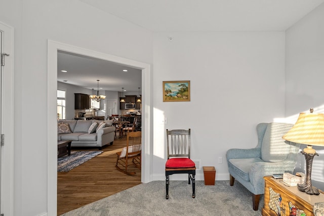 sitting room with hardwood / wood-style floors and a notable chandelier