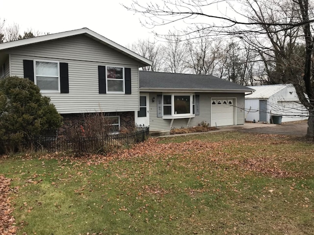 split level home with a garage and a front lawn