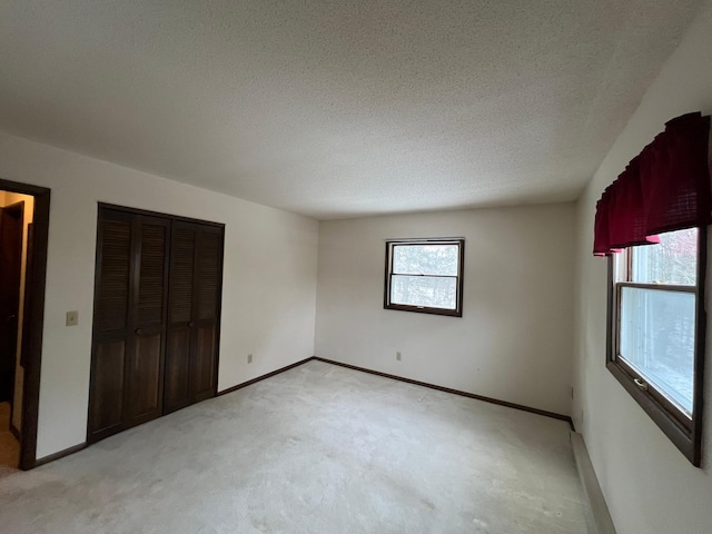 unfurnished bedroom featuring light colored carpet and a textured ceiling