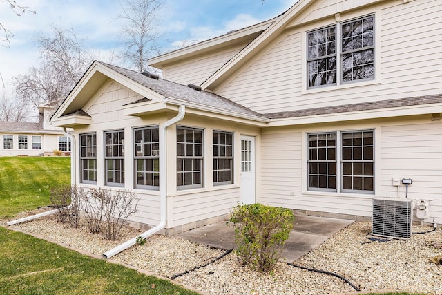 view of property exterior featuring a lawn and central AC