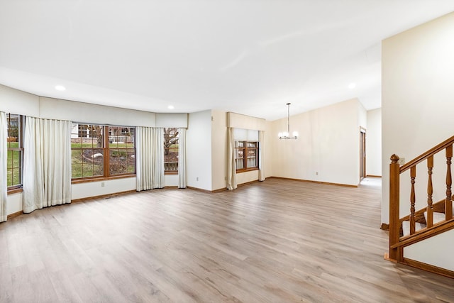 unfurnished living room with light hardwood / wood-style flooring and an inviting chandelier