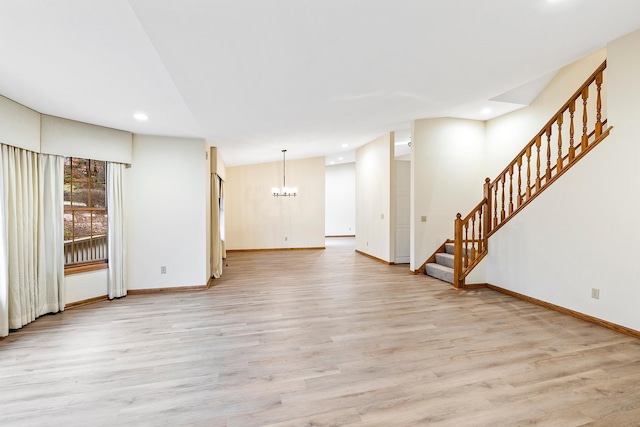 unfurnished living room with a notable chandelier and light hardwood / wood-style flooring