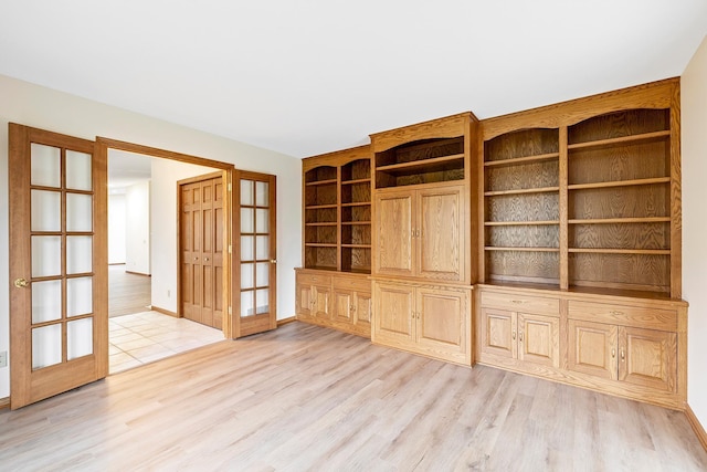 unfurnished living room featuring light hardwood / wood-style flooring and french doors