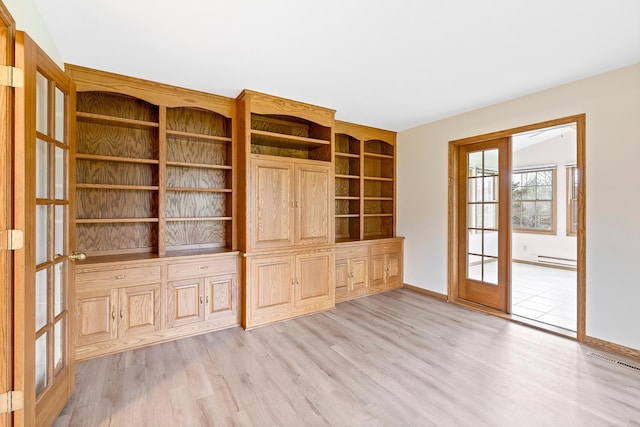 unfurnished living room with baseboard heating, french doors, and light hardwood / wood-style flooring