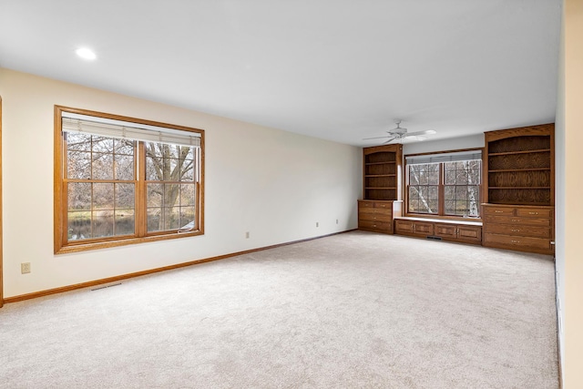 unfurnished living room featuring ceiling fan and light colored carpet