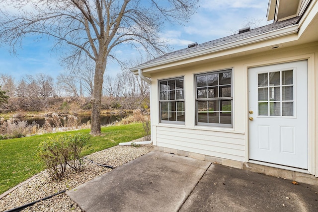 entrance to property featuring a yard and a patio