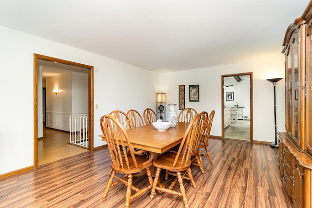 dining space featuring baseboards and dark wood finished floors
