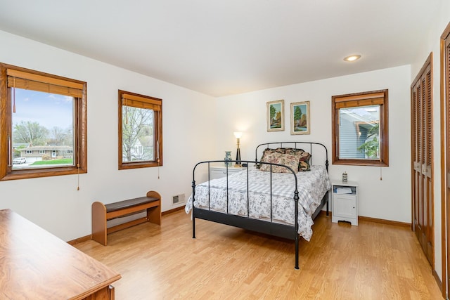 bedroom with a closet, visible vents, recessed lighting, light wood-style flooring, and baseboards
