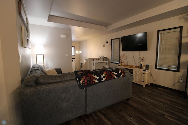 living room featuring dark hardwood / wood-style flooring and a raised ceiling