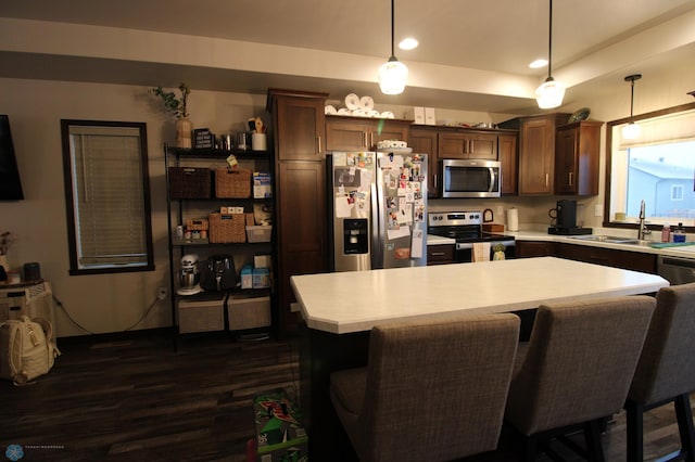 kitchen featuring a kitchen island, appliances with stainless steel finishes, sink, and pendant lighting