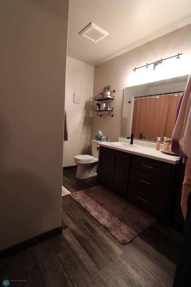 bathroom featuring vanity, hardwood / wood-style floors, and toilet