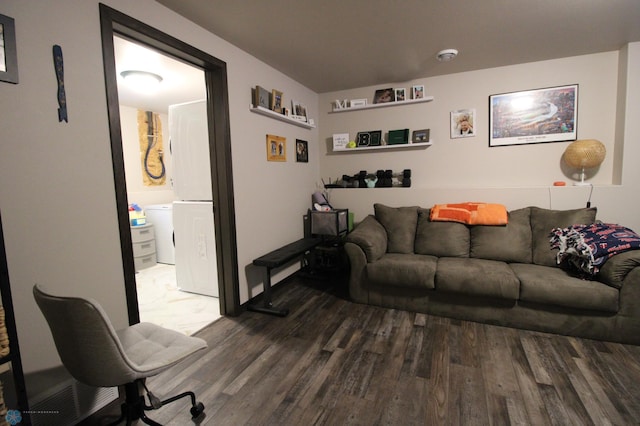 living room with wood-type flooring and washer / dryer