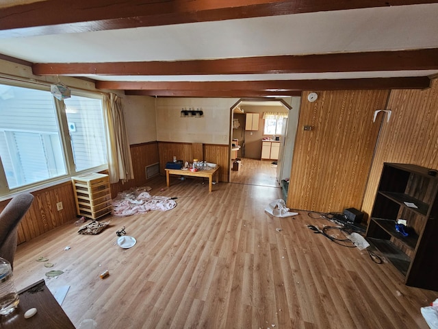 living room featuring beamed ceiling, hardwood / wood-style floors, and wooden walls