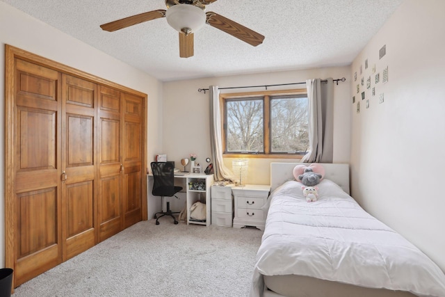 bedroom featuring a closet, a textured ceiling, carpet flooring, and ceiling fan