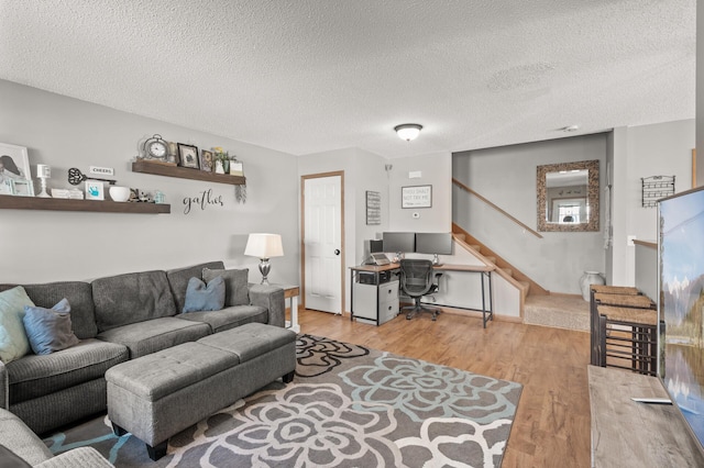 living room featuring a textured ceiling and light hardwood / wood-style flooring