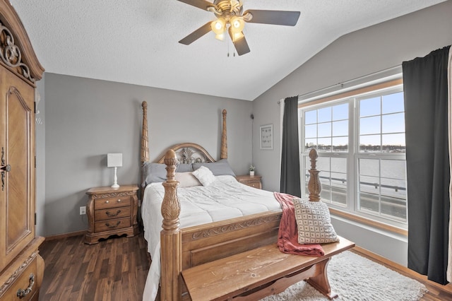 bedroom with ceiling fan, dark wood-type flooring, a textured ceiling, and vaulted ceiling