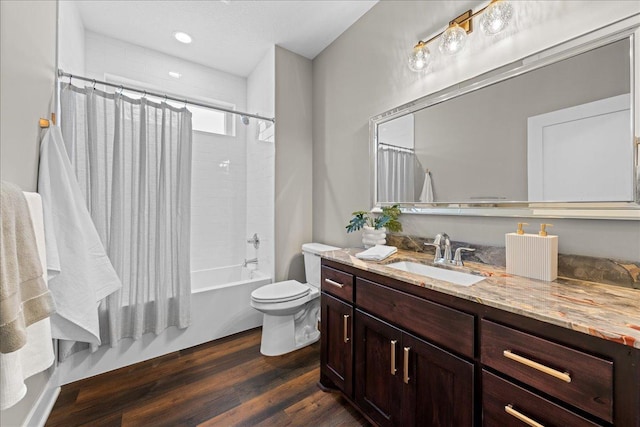 full bathroom with shower / bath combo, hardwood / wood-style floors, vanity, and toilet