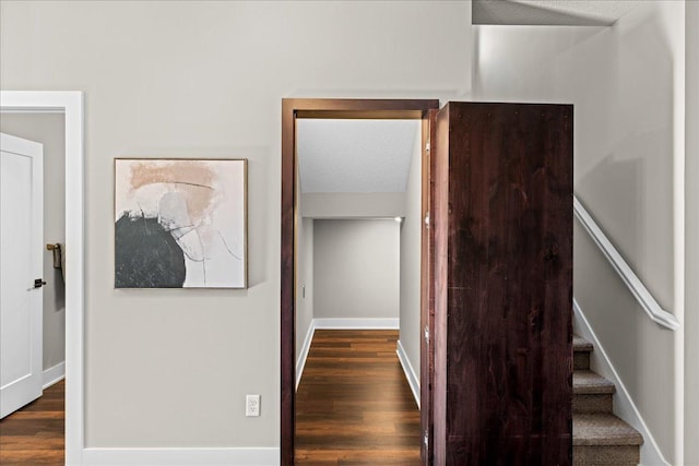 staircase with wood-type flooring and a textured ceiling