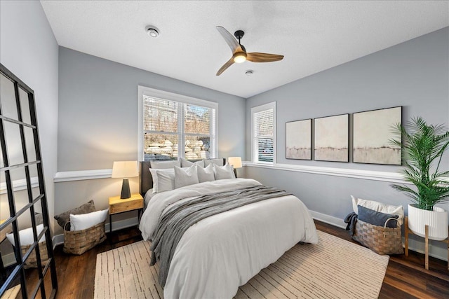 bedroom with dark hardwood / wood-style flooring, a textured ceiling, and ceiling fan