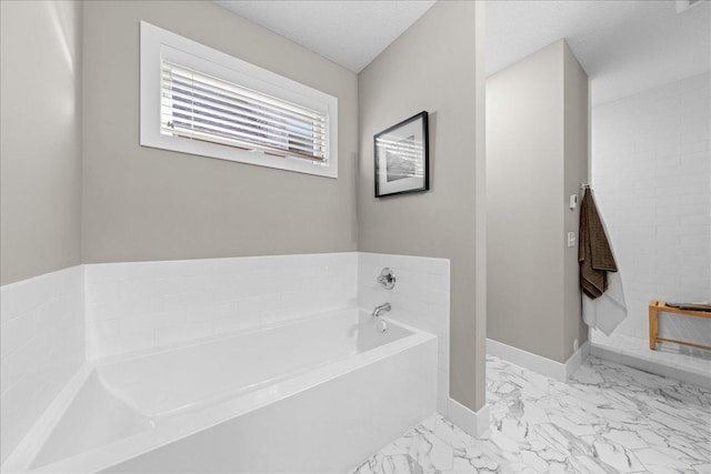 bathroom with a textured ceiling and a bathtub