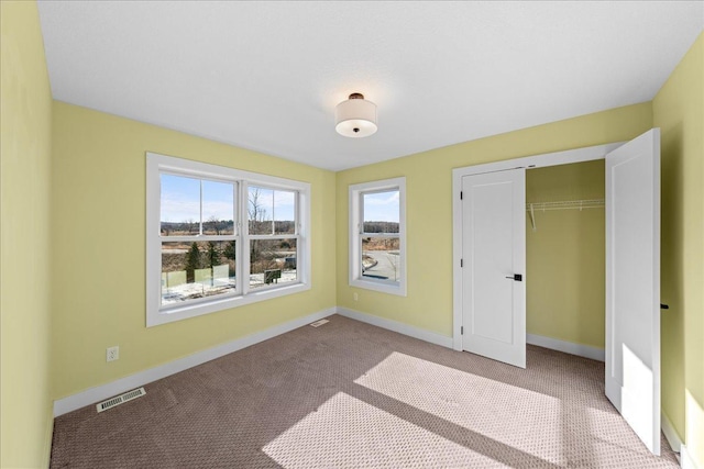 unfurnished bedroom featuring a closet and light carpet