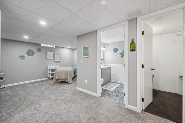 carpeted bedroom featuring a paneled ceiling and ensuite bathroom