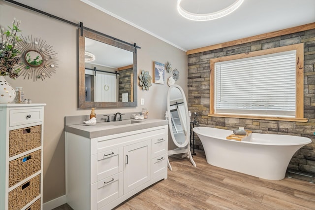 bathroom with crown molding, vanity, a bathing tub, and hardwood / wood-style floors