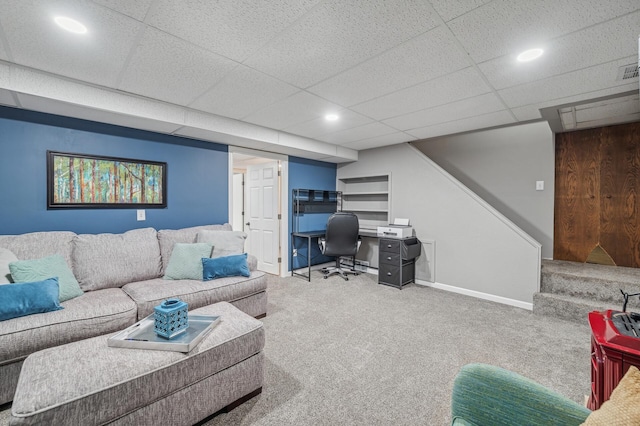 carpeted living room featuring a drop ceiling