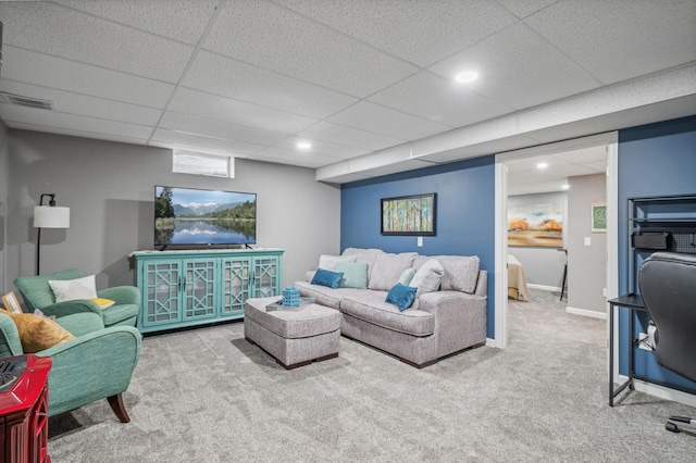 carpeted living room with a paneled ceiling