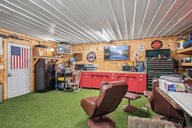 misc room with dark carpet, wooden walls, and a workshop area