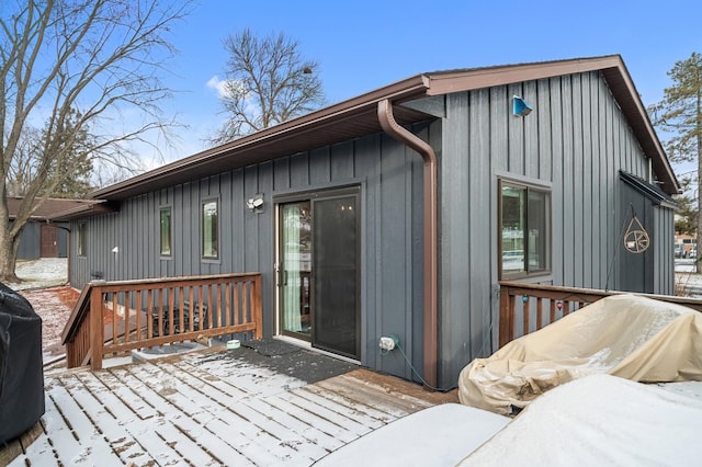 snow covered deck with a grill