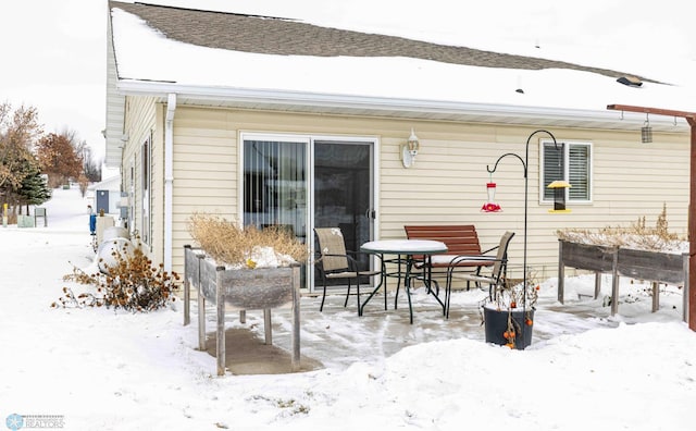 view of snow covered rear of property