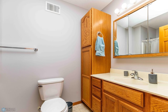 bathroom with tile patterned flooring, vanity, and toilet