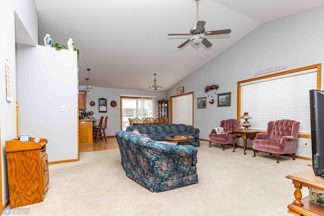 carpeted living room featuring ceiling fan with notable chandelier and lofted ceiling