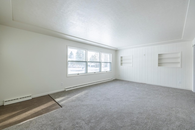 unfurnished room featuring a textured ceiling, carpet floors, and baseboard heating