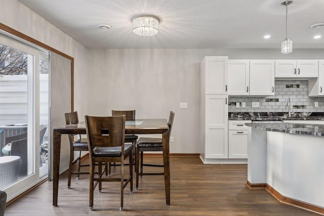 kitchen with white cabinets, decorative light fixtures, dark wood-type flooring, and a chandelier