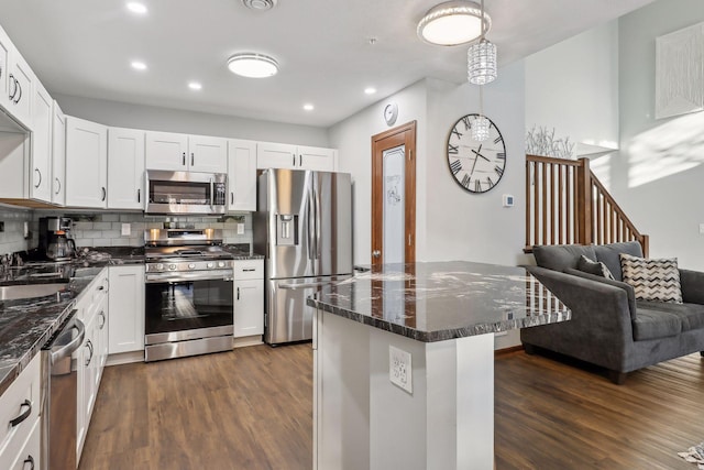 kitchen featuring white cabinets, dark hardwood / wood-style flooring, stainless steel appliances, and backsplash